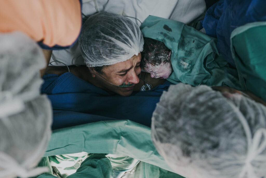 Mother holding newborn during delivery, highlighting maternal medical negligence risks.