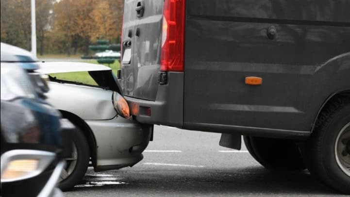 Underride accident involving a sedan and truck, highlighting rear-end collision damage