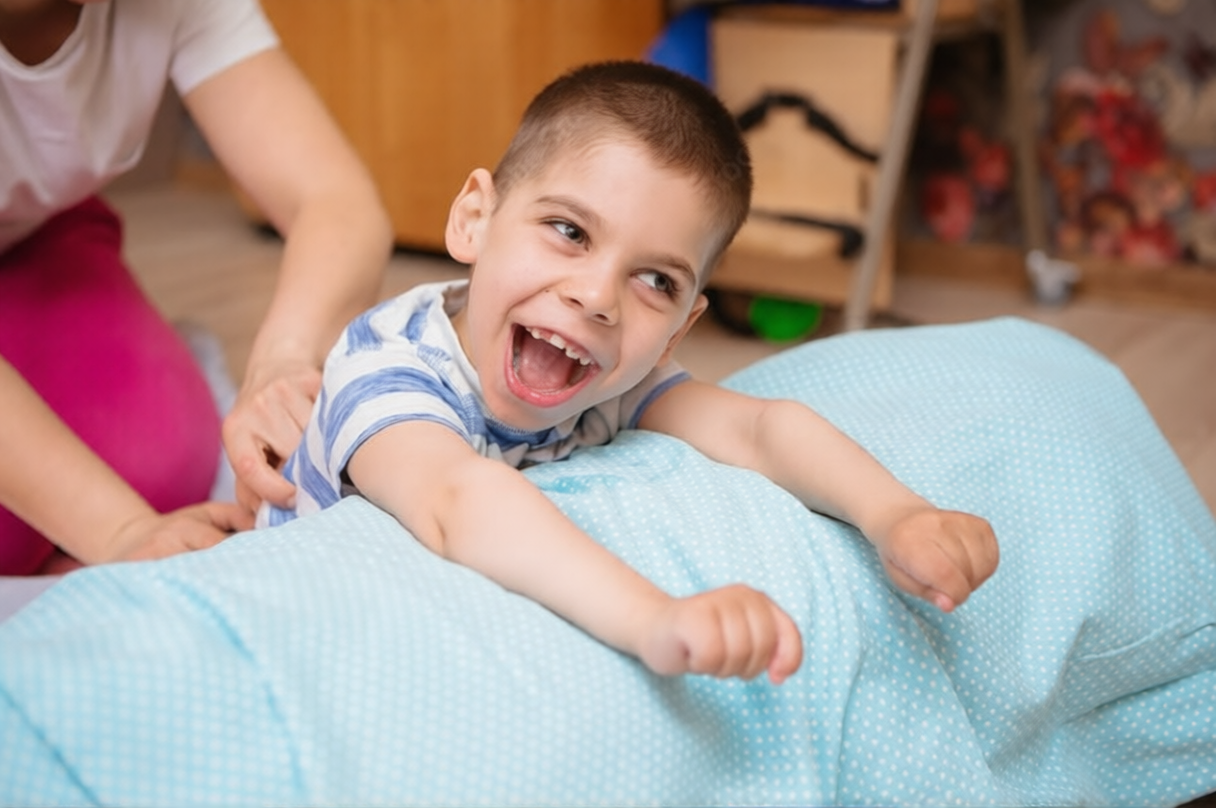 Child with cerebral palsy receiving supportive physical therapy during rehabilitation session.