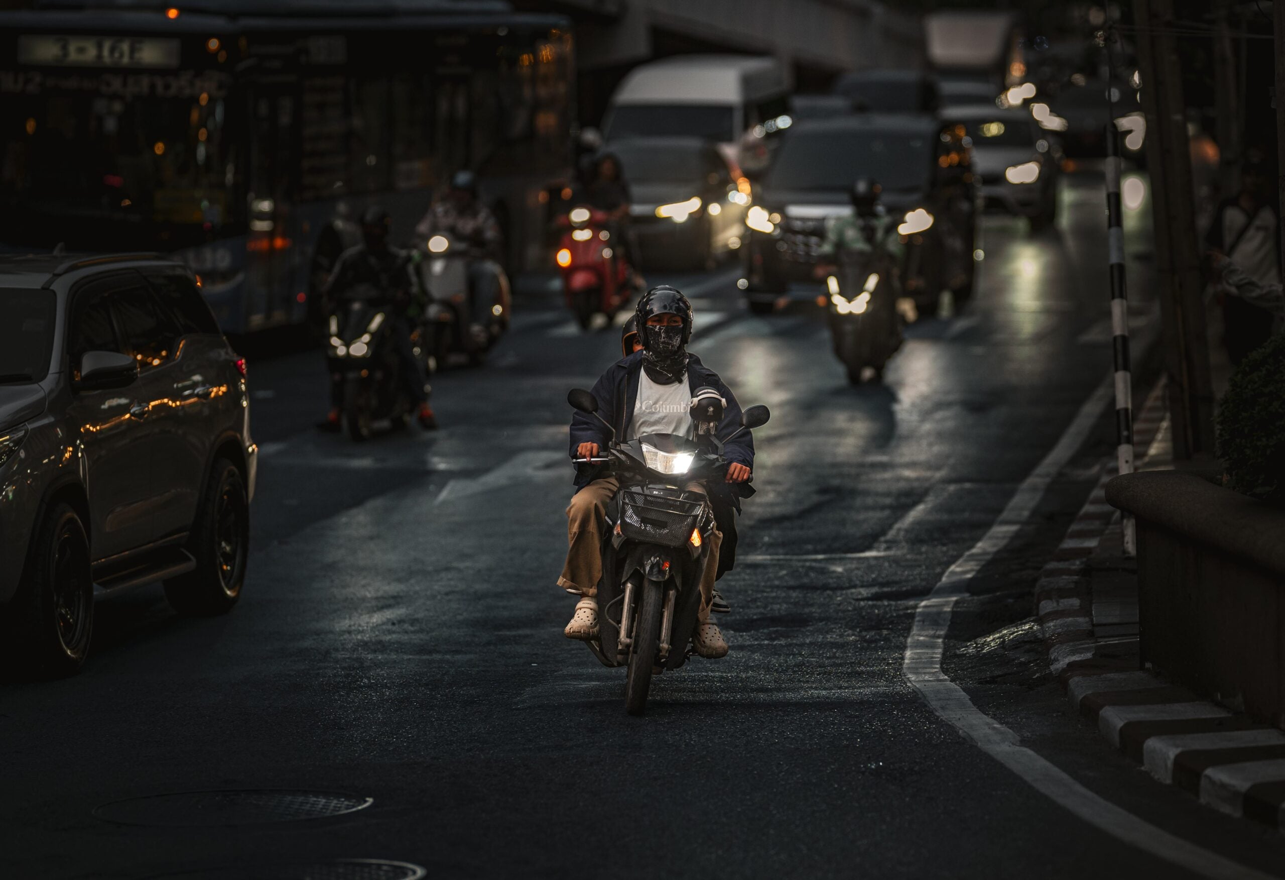 Motorcyclist riding through busy New York traffic at night during accident fault scenario