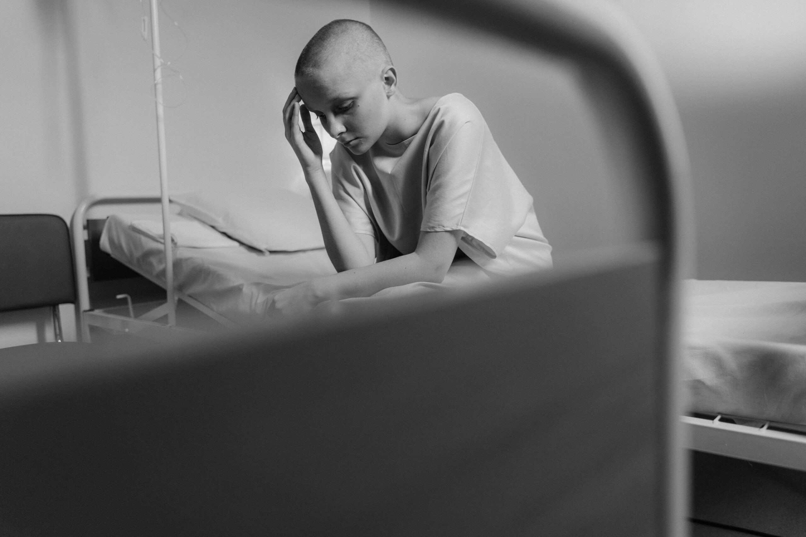 Patient in hospital looking concerned while doctor reviews charts, representing cancer misdiagnosis case.