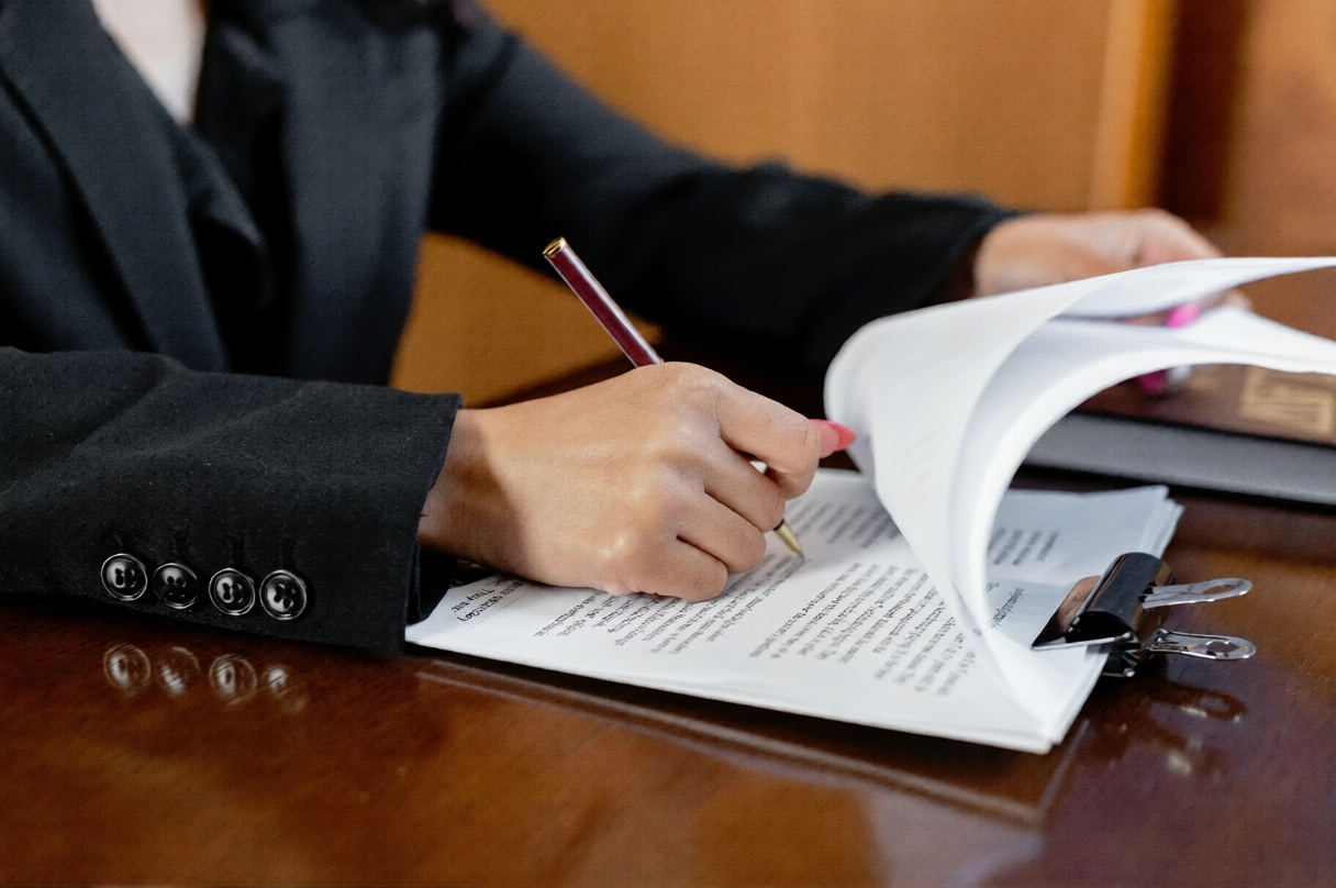 Attorney reviewing and signing Notice of Claim legal paperwork for New York injury case.