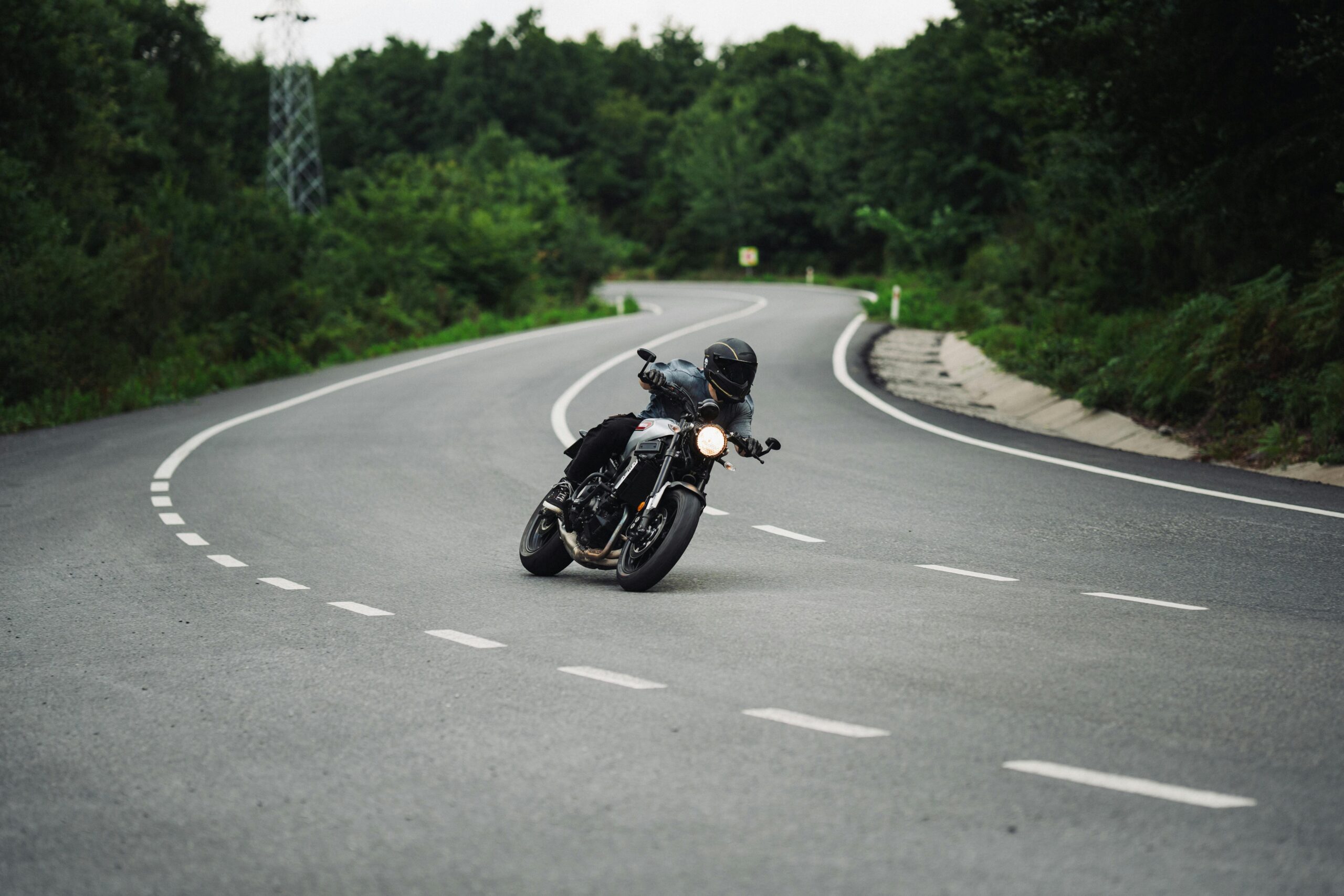 Motorcyclist riding on curved Syracuse roadway before a serious motorcycle accident scene.