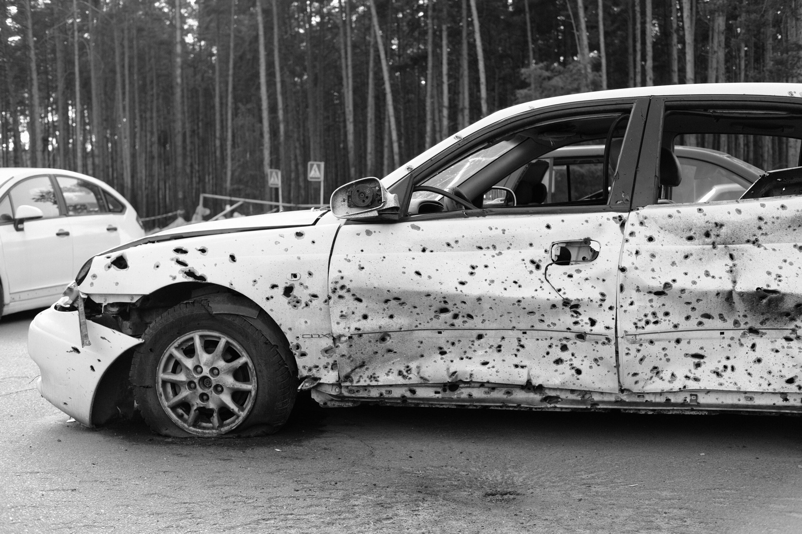 Damaged white car after a severe car accident with visible dents and scratches