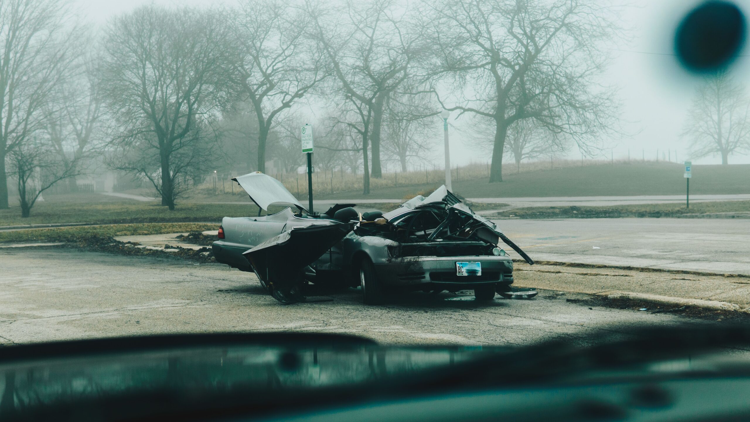 Head-on collision aftermath showing a severely damaged vehicle at a crash scene.