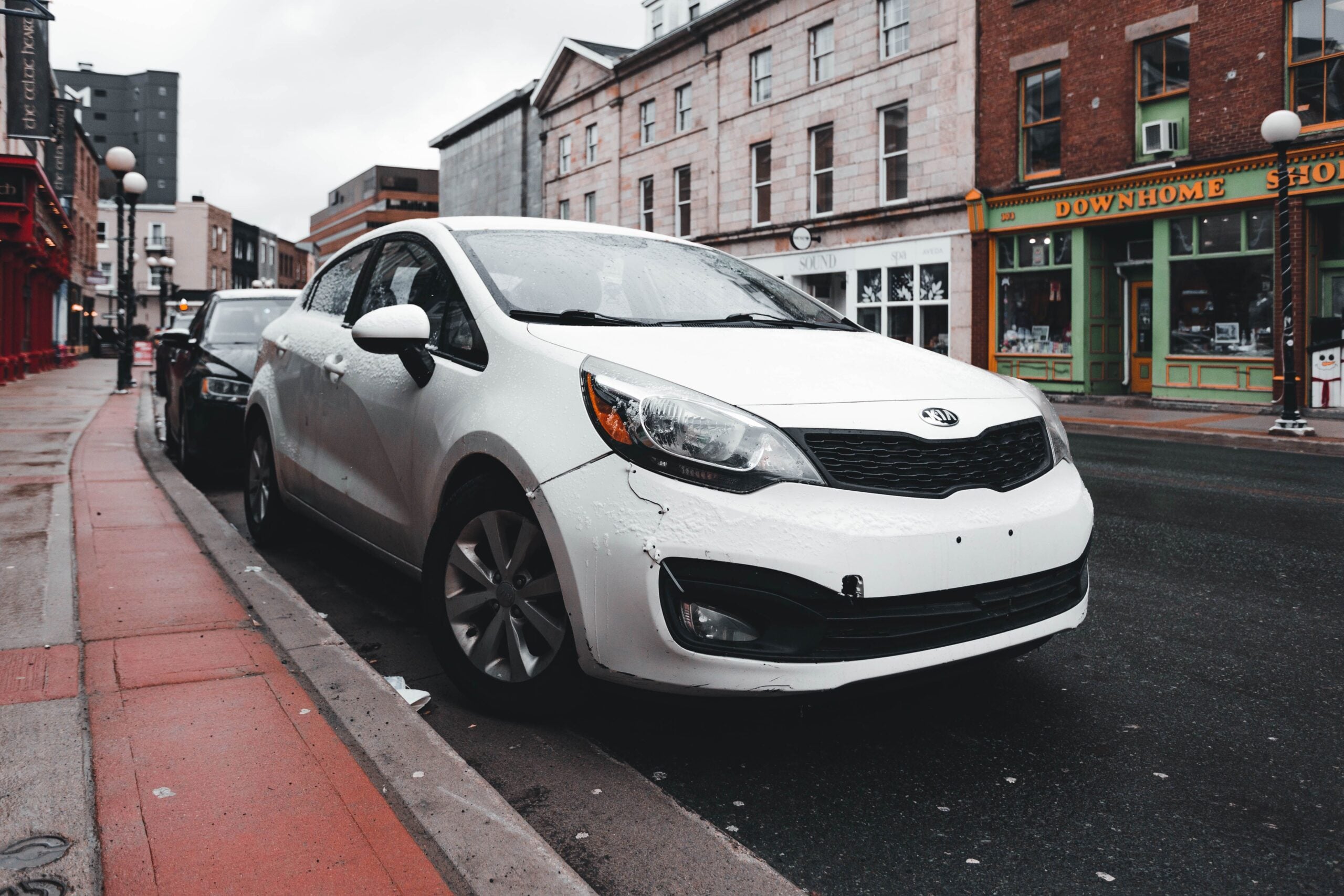 White rideshare vehicle parked on a city street, representing a potential Lyft accident