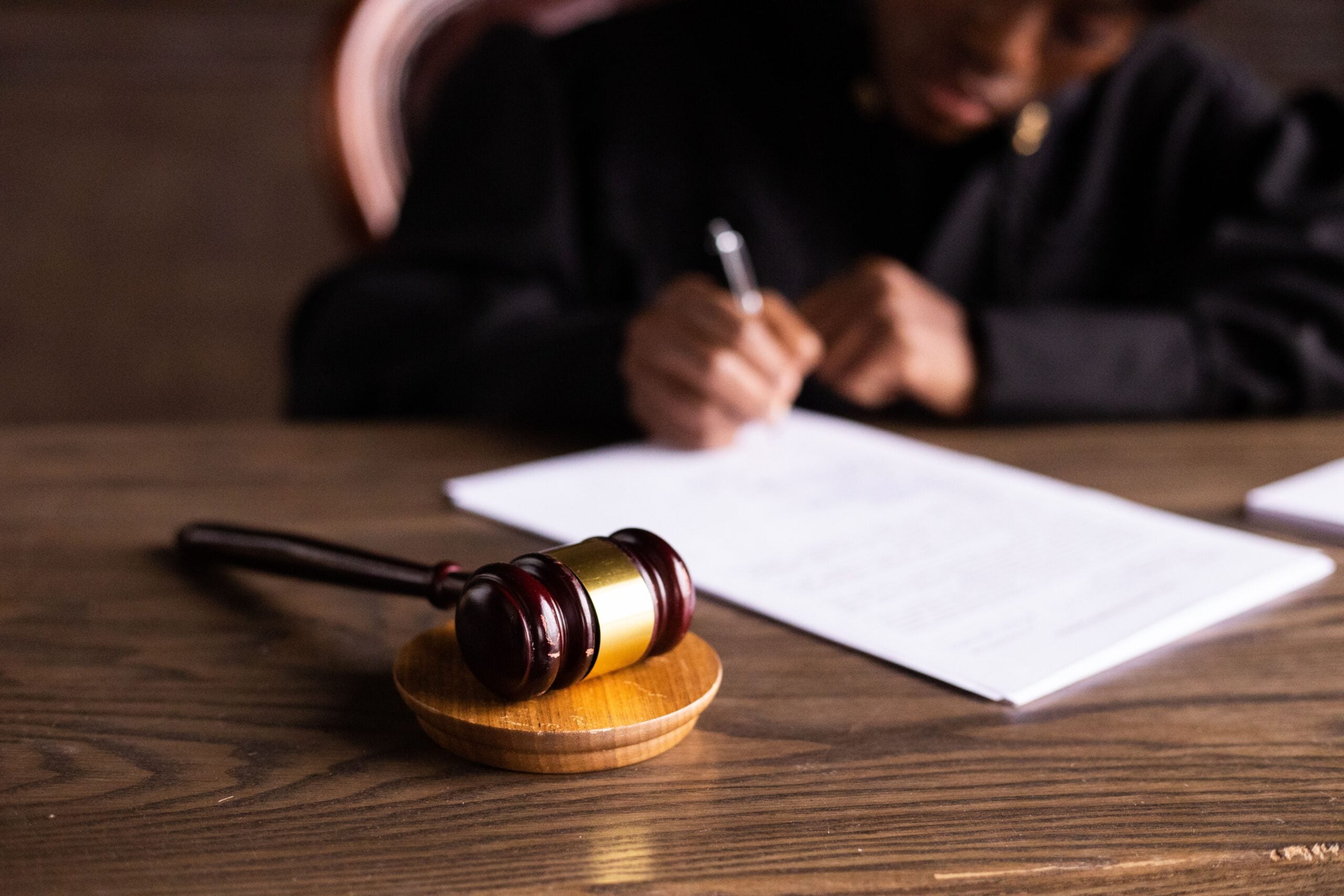 Car accident lawyer reviewing legal documents beside a judge's gavel in an office.